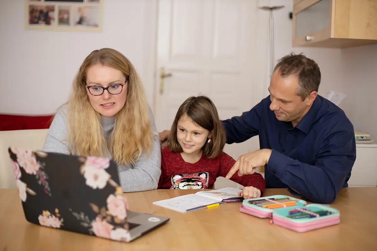 parents teaching child on laptop