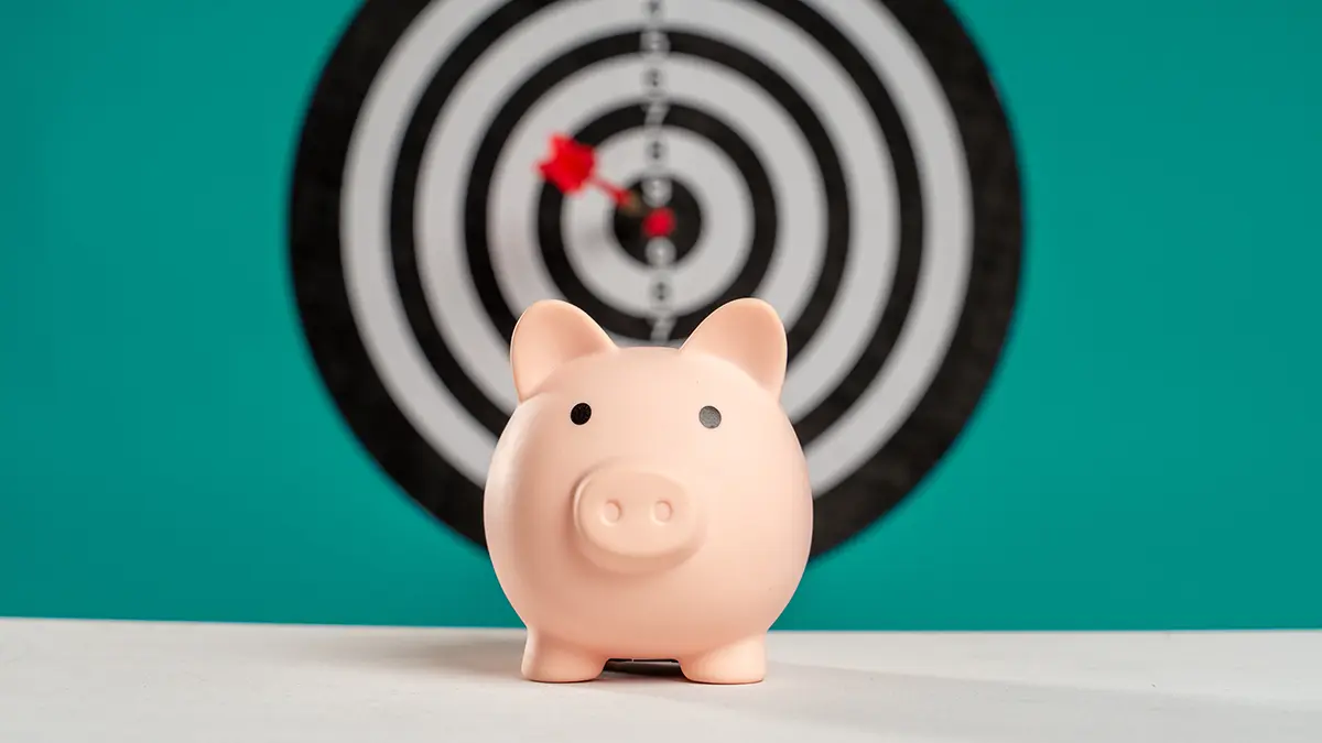 piggy bank in front of a dart board