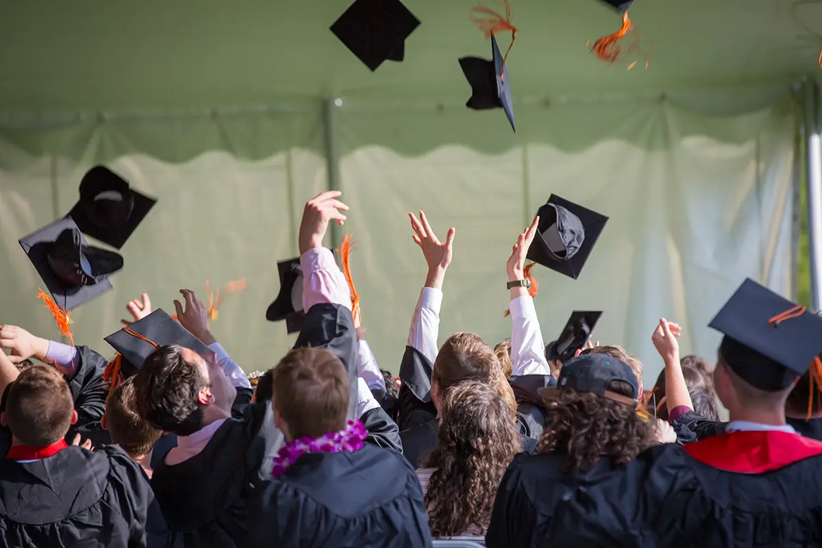 college graduates throwing their caps in the air